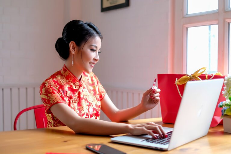 Happy chinese new year. Chinese woman in traditional clothing and shopping online.